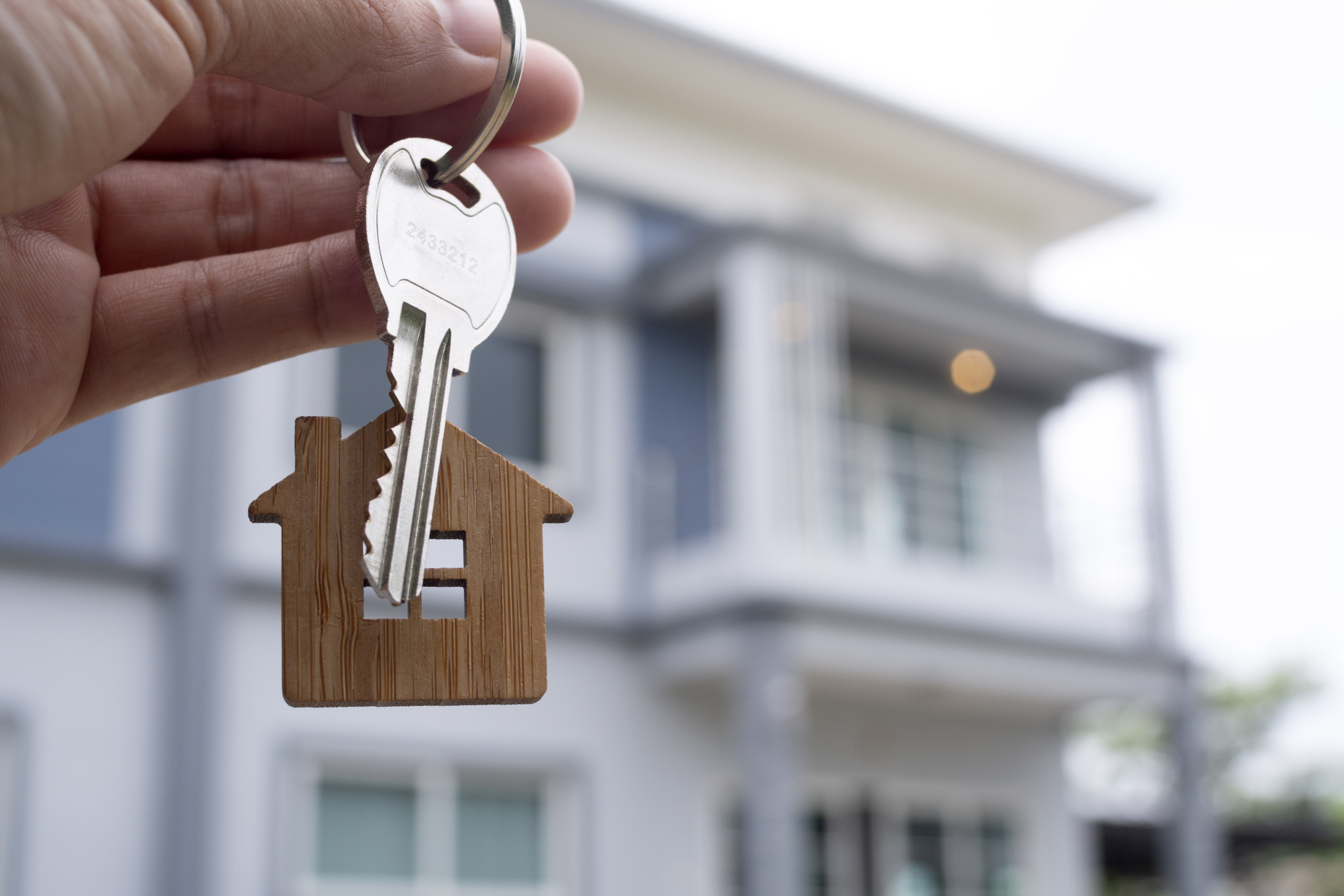 landlord-unlocks-house-key-new-home-real-estate-agents-sales-agents-scaled